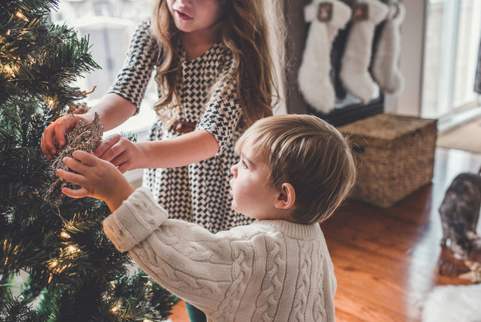 Enfants décorant le sapin de Noël